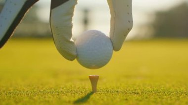 Golfçü golf sahasındaki golf sahasına golf topu koyuyor. Kapatın. İnsanlar, spor, boş zaman aktivitesi, eğlence ve yaşam tarzı. 