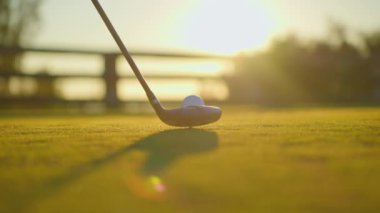 Yavaş çekimde golf sporu konsepti, golf sahasında golfçülerin golf sahasında kazanmak için deliğe vurması günbatımında güzel bir çim yoldur. Yeşil çimlere yakın şut atılıyor. Yazın rahatlamak için oynayan oyuncu için..