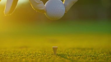 Golfçü golf sahasındaki golf sahasına golf topu koyuyor. Kapatın. İnsanlar, spor, boş zaman aktivitesi, eğlence ve yaşam tarzı. 