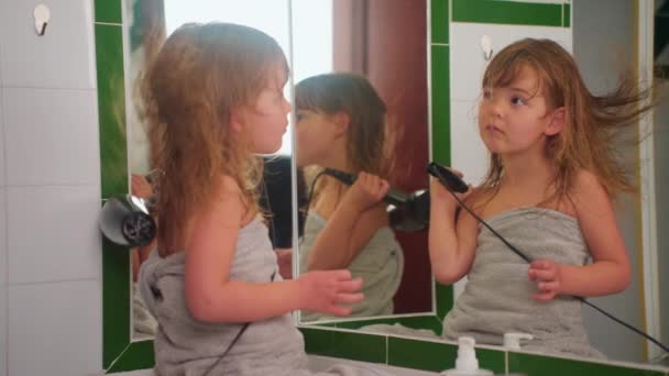 Χαριτωμένο Κοριτσάκι Στεγνώνει Μαλλιά Της Τον Εαυτό Της Ένα Στεγνωτήρα — Αρχείο Βίντεο