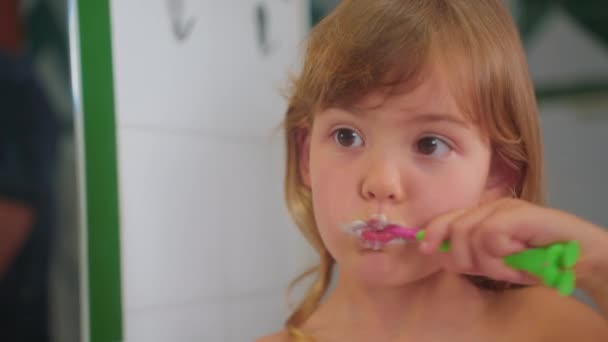 Kis Aranyos Lány Szorgalmasan Mossa Fogát Egy Fogkefével Miközben Tükörbe — Stock videók