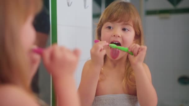 Aranyos Kislány Tükör Előtt Fürdőszobában Egy Törülközőben Tisztítja Nyelvét Egy — Stock videók
