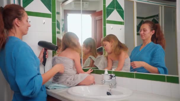 Szczęśliwa Matka Suszy Włosy Córki Prysznicu Stojąc Przed Lustrem Łazience — Wideo stockowe