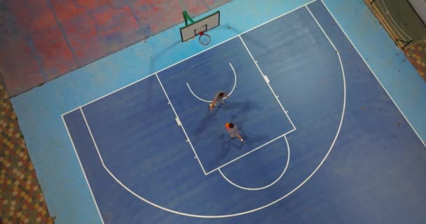 息子と一緒にバスケットボールをプレーするバスケットボールコートの空中ビュー ストリートバスケットボールのトップビュー — ストック動画