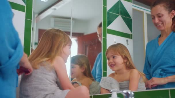 Happy Mother Combing Her Little Cute Daughters Hair Front Mirror — Stock Video