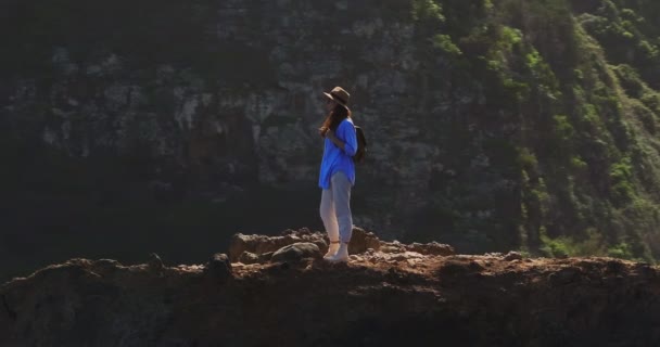 旅行者在天堂的岛上散步 活跃的年轻女子穿着远足或登山靴或鞋子在春季远足时爬到悬崖顶上观看风景 — 图库视频影像