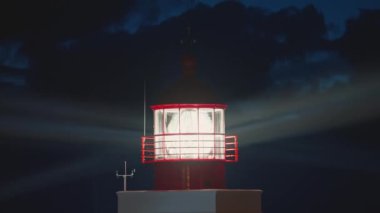 Günbatımında modern deniz feneri. Parlak ışık lensleri dönüyor ve Madeira adasındaki okyanusa doğru parıldıyor..