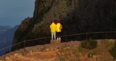 Sırt çantalı iki turist gün batımında güneşin parlaklığında ağır çekimde yürüyorlar. Kamera bir çifti gezide ya da macerada takip ediyor. Aile güzel dağ vadisinde yürür.