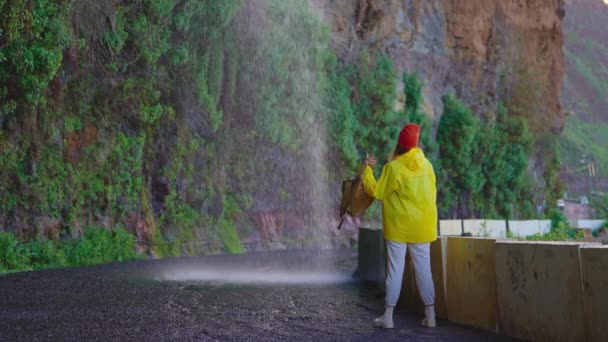 Dağlık Bölgelerdeki Şelalenin Yakınındaki Sarı Yağmurluklu Bir Kadın Gezgin Doğa — Stok video