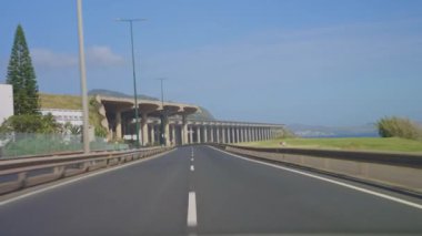 POV araç sürücüsü. Portekiz 'in Madeira adasındaki yerel bir havaalanının pistinin altından bir araba geçiyor..