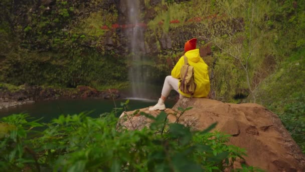 Dağlık Bölgelerdeki Şelalenin Yakınındaki Sarı Yağmurluklu Bir Kadın Gezgin Doğa — Stok video
