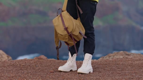 一个穿着旅游服的女孩穿着靴子和背包站在山的边缘 相机的主要焦点都指向她 旅行和探险概念 — 图库视频影像