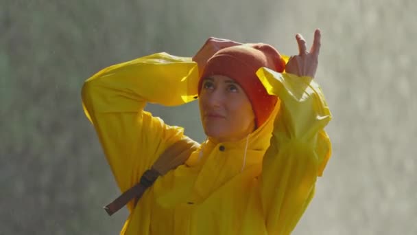 Портрет Девушки Жёлтом Плаще Стоящей Брызгами Водопада Надевающей Капюшон Защитить — стоковое видео