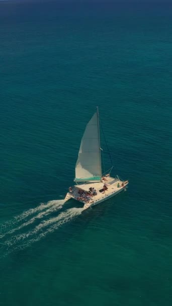 インド洋上空でドローン飛行 空中映像 白い目覚めのある深い青い海を航行する豪華な帆船のリアビュー カメラは青い海水のカタマランに従います — ストック動画