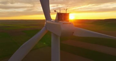 Alternatif enerji. Yel değirmenlerinin hava manzarası. ABD 'de enerji üretimi. Rüzgâr türbinleri olan bir manzara. Geniş rüzgar türbinleri ve saha manzarası parlak turuncu günbatımı..