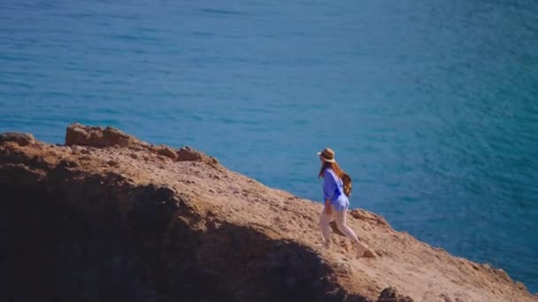 カメラはバックパックで女性のハイカーをフォローします トラベラー ハイカーは自然と人生を楽しんでいる 山を旅する 旅行の冒険 ライフスタイルコンセプト マデイラの山道を歩いている女性 — ストック動画