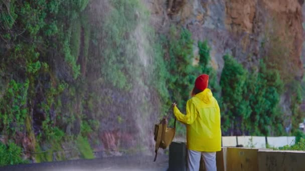노란색 재킷과 배낭에 여자는 폭포의 놀라운 전망을 서사시 풍경을 — 비디오
