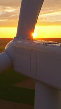 Alternatif enerji. Yel değirmenlerinin hava manzarası. ABD 'de enerji üretimi. Rüzgâr türbinleri olan bir manzara. Geniş rüzgar türbinleri ve saha manzarası parlak turuncu günbatımı..