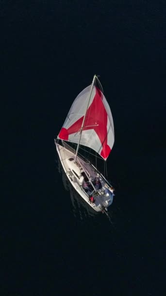 太陽の光線に帆で白いヨットの空中撮影を確立する 水の上に輝いている 青い海のセーリングヨットのシルエット ドローンからのショット — ストック動画