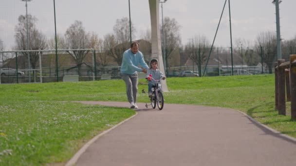 Mała Dziewczynka Jeżdżąca Rowerze Parku Ostrożnym Ojcem Który Uczy Jeździć — Wideo stockowe