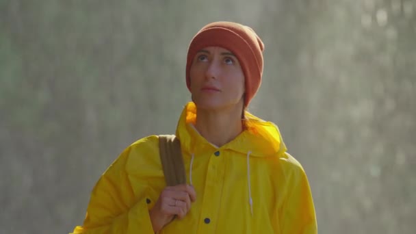 Портрет Девушки Жёлтом Плаще Стоящей Спреем Водопада Смотрящей Вокруг Неё — стоковое видео