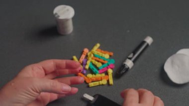 Şeker hastalığı olan şeker hastası yaşlı kadın evdeki glukometreyle kan şekerini ölçüyor. Sağlık hizmeti, diyabetik yaşam tarzı.