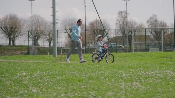Mała Dziewczynka Jeżdżąca Rowerze Parku Ostrożnym Ojcem Który Uczy Jeździć — Wideo stockowe
