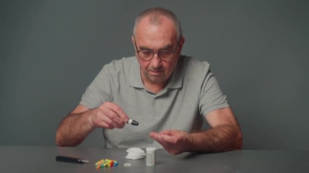 一位被诊断患有糖尿病的老年男子用可替换针头的便携式糖蜜计快速进行血糖检测 — 图库视频影像