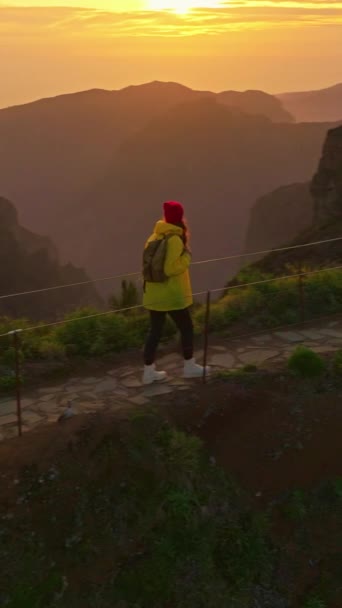 バーティカルビデオ カメラはバックパックで女性のハイカーをフォローします トラベラー ハイカーは自然と人生を楽しんでいる 山を旅する 旅行の冒険 マデイラの山道を歩いている女性 — ストック動画