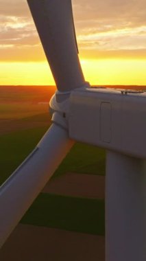 Alternatif enerji. Yel değirmenlerinin hava manzarası. ABD 'de enerji üretimi. Rüzgâr türbinleri olan bir manzara. Geniş rüzgar türbinleri ve saha manzarası parlak turuncu günbatımı..