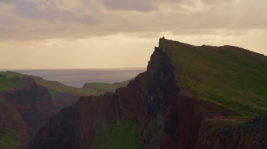 Mavi Atlantik Okyanusu 'nun yanındaki kayalık sahil şeridi. Yeşil bir adanın kıyısında. Dağları ve okyanus kayalıkları olan Madeira manzarası. Madeira Adası 'nın engebeli kıyı şeridine nefes kesici bir manzara..