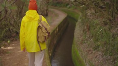 Kamera kadın yürüyüşçüyü sırt çantasıyla takip ediyor. Gezgin yürüyüşçü, doğa ve hayatın tadını çıkarıyor. Dağlarda seyahat, yolculukta macera. Yaşam tarzı konsepti. Madeira 'da dağ yolunda yürüyen bir kadın..