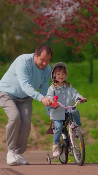 Vertical Video Little Girl Cycling Park Careful Father Who Teaching — Vídeo de Stock