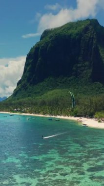 Uçurtma uçağı, insansız hava aracından gelen berrak kristal suda uçurtma hızıyla uçuyor. Bir atlet, Mauritius adasında Hint Okyanusu 'nda uçurtma sürüyor. Adanın yakınında canlı bir resif. Denizin fethi.