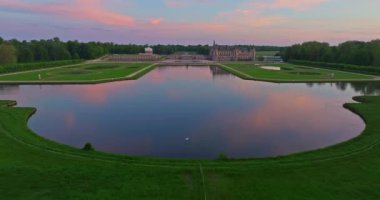 Chantilly Castle, France. Incredible view of the castle and its surrounding area at sunset from a drone.