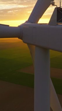 Alternatif enerji. Yel değirmenlerinin hava manzarası. ABD 'de enerji üretimi. Rüzgâr türbinleri olan bir manzara. Geniş rüzgar türbinleri ve saha manzarası parlak turuncu günbatımı..
