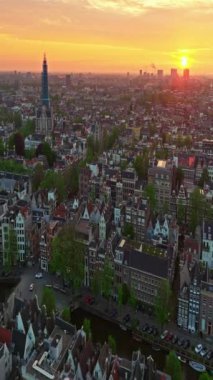 Amsterdam, Hollanda şehri. Şehir merkezinde elektrikli tekneleri olan kanalların havadan görüntüsü. İnsansız hava aracı Amsterdam bahar manzarası dar eski evler, kanallar. Eski merkez hava görüntüsü oluşturuluyor.