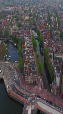 Amsterdam, Hollanda şehri. Şehir merkezinde elektrikli tekneleri olan kanalların havadan görüntüsü. İnsansız hava aracı Amsterdam bahar manzarası dar eski evler, kanallar. Eski merkez hava görüntüsü oluşturuluyor.