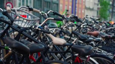 Kanal boyunca turist teknesi, köprüsü ve eski evleri bulunan Amsterdam manzaralı kanalı kuruluyor. İnsanlar bisiklet ve elektrikli tekne kullanıyor..