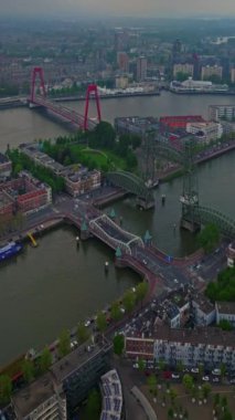Hollanda 'daki Rotterdam şehrinin havadan görüntüsü. Varış yeri Hollanda. Erasmusbrug ve nehir Maas şehir manzarası gün batımında.