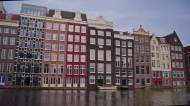 Hollanda 'nın Amsterdam kentinin mimarisiyim. Geleneksel evler, kanallar, bisikletler, şehir ulaşımı. Avrupa 'da bir şehrin turizm merkezi. Şehirde dolaşan ve gezen bir sürü insan..