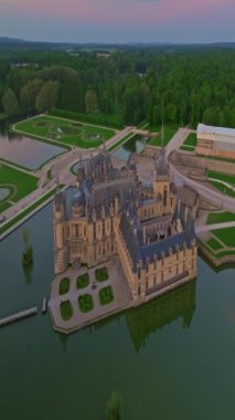 Chantilly Castle, France. Incredible view of the castle and its surrounding area at sunset from a drone.