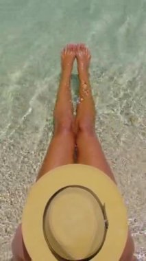Seyahatin ve yaz tatilinin tadını çıkarıyorum. Beyaz bikini giyen genç bir kadın cennet adası tatili hayallerini gerçekleştiriyor. Atletik ve güzel bir kadın figürü..