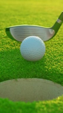 Çok yönlü bir video. Golf eldiveni giymiş bir erkek topu sahaya sürüyor. Golfçü golf sahasındaki golf sahasına golf topu koyuyor. Kapat..