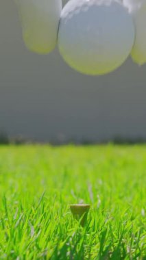 Çok yönlü bir video. Golf eldiveni giymiş bir erkek topu sahaya sürüyor. Golfçü golf sahasındaki golf sahasına golf topu koyuyor. Kapat..