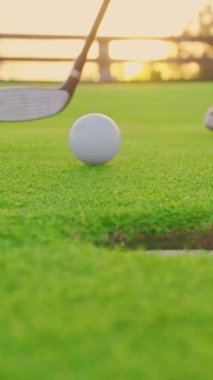 Çok yönlü bir video. Golf eldiveni giymiş bir erkek topu sahaya sürüyor. Golfçü golf sahasındaki golf sahasına golf topu koyuyor. Kapat..