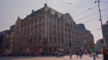 Amsterdam, Hollanda, 09 Haziran 2024: Kanal boyunca eski evler ve geçen turist teknesi ile Amsterdam manzaralı şehir manzaralı kanal kurma. Bisiklet ve elektrik taşımacılığı.