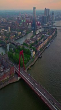 Hollanda 'daki Rotterdam şehrinin havadan görüntüsü. Varış yeri Hollanda. Erasmusbrug ve nehir Maas şehir manzarası gün batımında.