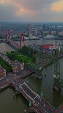 Hollanda 'daki Rotterdam şehrinin havadan görüntüsü. Varış yeri Hollanda. Erasmusbrug ve nehir Maas şehir manzarası gün batımında.