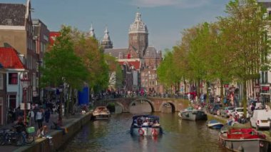 Hollanda, Amsterdam, 24 Haziran 2024: Geleneksel evler, kanallar, bisikletler, kentsel ulaşım. Avrupa 'da bir şehrin turizm merkezi. Şehirde dolaşan ve gezen bir sürü insan..